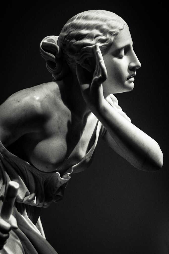 Graceful marble statue of a woman, capturing an artistic moment indoors.