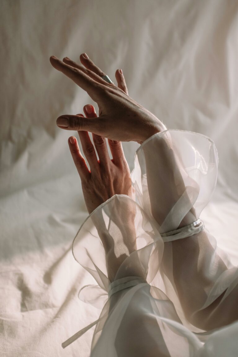 A close-up of graceful hands wrapped in translucent silk fabric, showcasing elegance and creativity.