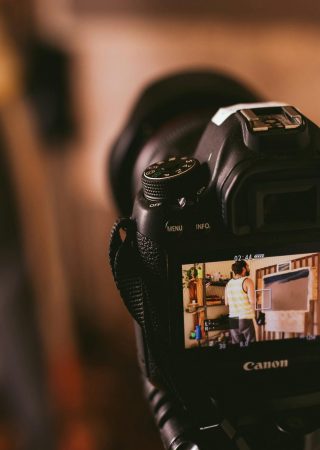 Close-up view of a DSLR camera screen capturing a person in a studio setting, focusing on technology and photography.