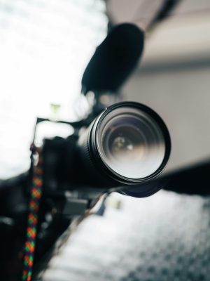 Close-up view of a professional camera lens with microphone, ideal for photography and videography enthusiasts.